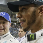 Valtteri Bottas y Lewis Hamilton sonrien tras lograr el finlandés la última pole de la temporada en Abu Dabi.