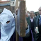 Un papón porta la cruz ante la mirada de numeroso público