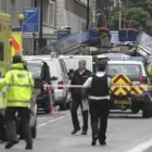 Personal de los servicios de emergencia trabajan en las cercanías de los restos del bus que explotó en Tavistock Square, en Londres.