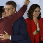 Feijóo y Almeida se funden en un abrazo ante Ayuso ayer, en el balcón de la sede del PP en Génova. JUANJO MARTÍN