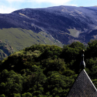 Un enorme manto negro de ceniza se observaba ayer, con el cielo limpio, desde el monasterio de San Pedro de Montes. El incendio originado en Montes de Valdueza hizo ayer una semana, con 1.435 hectáreas quemadas según la cifra oficial, ya ha superado en superficie al que también registró la Tebaida berciana en abril de 2017. El fuego seguía ayer en nivel 2 ante el fuerte viento previsto al final del día. ANA F. BARREDO