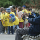 Un pensionista contempla a unos escolares en un parque.