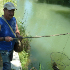 Un aficionado pesca cangrejos en las aguas del río Cea.
