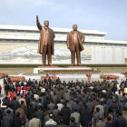 Norcoreanos participan en una ofrenda floral delante de las estatuas del fundador de Corea del Norte, Kim Il-sung, y de su hijo Kim Jong-il en Piongyang con motivo de la celebración del 101 aniversario del nacimiento del fundador del país, ayer.