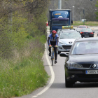 Un ciclista, en la entrada a León por la calle de La Granja, entre varios coches a una hora punta.