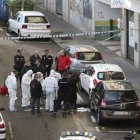 Agentes de la policía junto al cadáver del atracador a las puertas del banco.