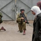 Dos mujeres palestinas pasan por delante de un soldado hebreo