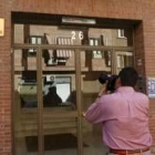 Un reportero gráfico fotografía la puerta de un edificio donde una mujer asesinó ayer a su pareja