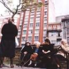 Un grupo de mujeres conversa en la calle mientras descansan al sol en un banco de un parque