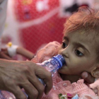 Un padre da de beber a su hija desnutrida el pasado mes de septiembre en un centro hospitalario de Hodeida, ciudad bombardeada por Arabia Saudí y sus aliados.