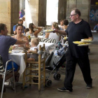 Un camarero sirve a un grupo de clientes en una terraza.