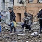 Los vecinos evacuan un edificio dañado con misiles en Kharkiv, al noreste de Ucrania. SERGEY KOZLOV