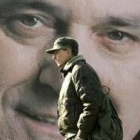 Un hombre pasa por delante de un cartel del candidato Nikolic