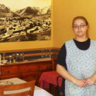 Gloria posa ante una foto del viejo Riaño que preside el comedor de su restaurante.