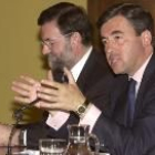 Ángel Acebes expone las líneas básicas de la Ley de Extranjería junto a Mariano Rajoy _al fondo_