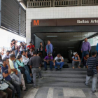 Personas esperan por el restablecimiento del transporte subterráneo tras un corte de energía. HERNÁNDEZ