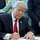 El presidente de Estados Unidos, Donald Trump, firma una orden ejecutiva en el despacho oval.