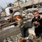 Unos niños, fotografiados entre escombros de su casa destruida por israelíes.