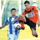 El deportivista Domenech controla el balón a media altura en una jugada en el mediocampo.