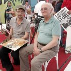 El artista leonés Félix de la Concha junto al escritor griego Petros Márkaris y el retrato del creador del comisario Jaritos.