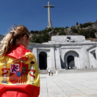 Una mujer envuelta en una bandera española en la explanada del Valle de los Caídos. MARISCAL
