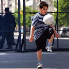Un niño juega con un balón en la calle. El ejercicio físico y la alimentación ayudan a prevenir la obesidad. CHICO SÁNCHEZ