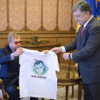 El presidente ucraniano, Petro Poroshenko, entrega una camiseta con la imagen de un cineasta encarcelado en Rusia al cantante Elton John.