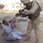 Un soldado apunta a un hombre en los alrededores de la casa en Mosul