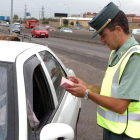 Un agente de la Guardia Civil de Tráfico examina la documentación de un vehículo.