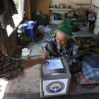 Una anciana deposita su voto en una urna móvil en el distrito uzbeko de Unadir.