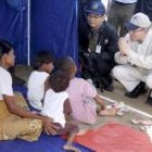 Ban Ki-moon conversando con una mujer y sus hijos refugiados en una tienda de campaña