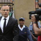 Oscar Pistorius (centro) abandona los juzgados de Pretoria, este viernes, tras el aplazamiento del juicio.