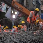 Trabajadores de emergencias indios en las tareas de rescate tras el derrumbamiento de un puente en Calcuta, India.