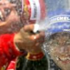 Schumacher celebra el triunfo en el podio con Button al fondo