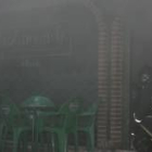 Un bombero, con una mascarilla, entra en el interior del restaurante