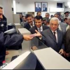 El presidente palestino, Mahmoud Abbás, recibe su pasaporte sellado en el cruce fronterizo de Rafá