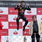 El australiano Mark Webber, de Red Bull, celebra en el podio con un gran salto su victoria en el Gran Premio de Gran Bretaña ante Alonso y su compañero Vettel.