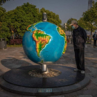 Un hombre observa una bola del mundo en Wuhan. ROMA PHILIPPEY
