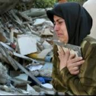 Una palestina se aferra a un marco de fotografía, lo único que se ha salvado de su casa