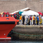 Decenas de personas llegadas en cayucos ayer, en el puerto de Arguineguín, en Gran Canaria. QUIQUE CURBELO