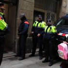 Los mossos saludando a una niña mientras esperan durante en la redada contra los narcopisos en la calle Sant Climent del Raval.