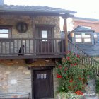 Fachada y dormitorio principal de la casa rural Era Marina, en Vega de Espinareda.