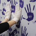 Una pared con manos lilas pintadas en un acto feminista.