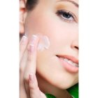 Una consumidora se aplica crema facial.