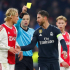 Sergio Ramos (d) recibe la amarilla durante el partido contra el Ajax.