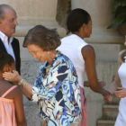 La Reina conversa con la pequeña Sasha mientras el Rey observa el saludo de Michelle Obama y Letizia