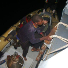 Algunos de los inmigrantes rescatados suben al buque de la Marina italiana, anoche.