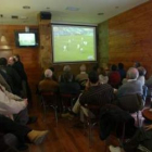 Un grupo de personas mira la televisión en un establecimiento hostelero.