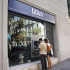 Dos clientes frente a un cajero del BBVA.