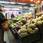 Una mujer, frente a la parada de un mercado.